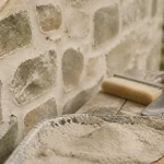 Jointage mur en pierre à la chaux : mortier et joints fraîchement rejointoyés